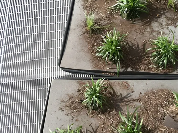 Dense welded steel grating next to planters in garden installation.