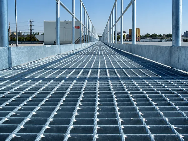 Installed steel grating walkway with safety railings.